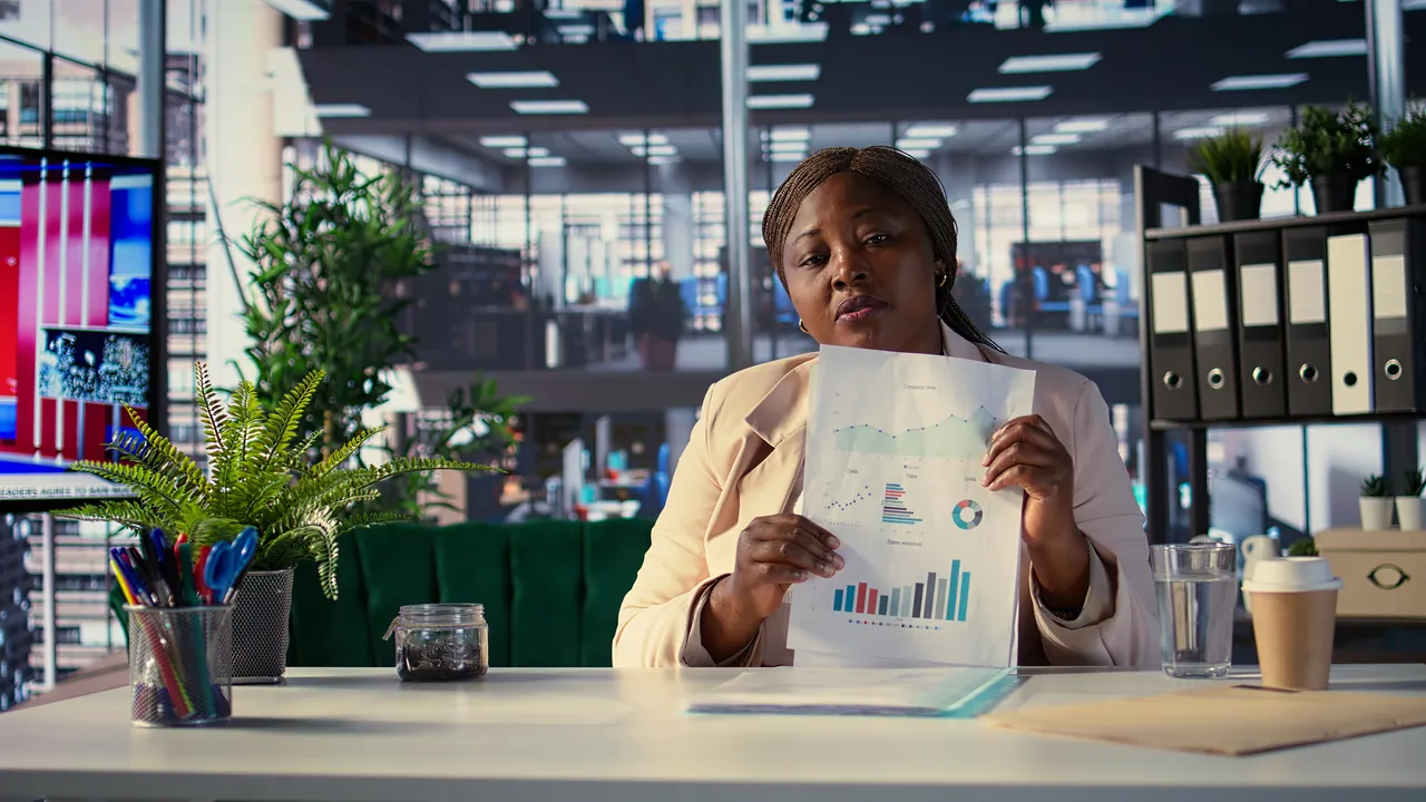 A pensions professional reviewing a printed performance chart at her desk